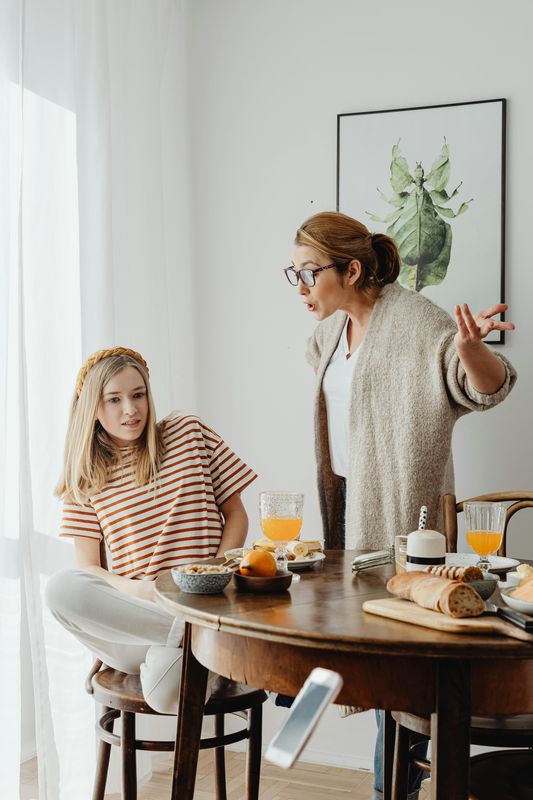 Une mère et sa fille en désaccord lors d'un repas — tensions du quotidien familial